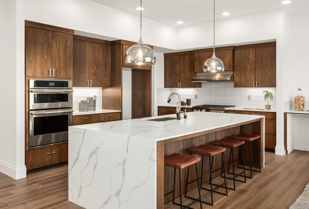 Kitchen,In,New,Luxury,Home,With,Quartz,Waterfall,Island,,Hardwood